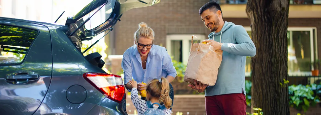 A family unloading groceries from their car