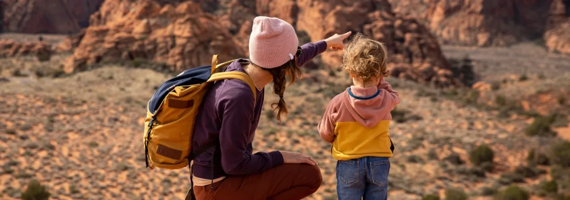 A woman and a child surveying a rocky desert landscape