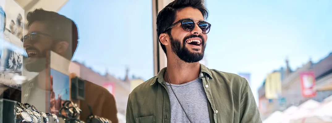 A man in sunglasses in front of a watch store