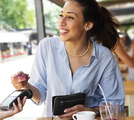 A woman paying for a meal using her Visa Signature card.