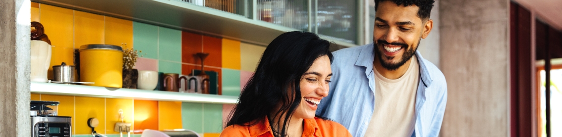 A couple smiling in a kitchen