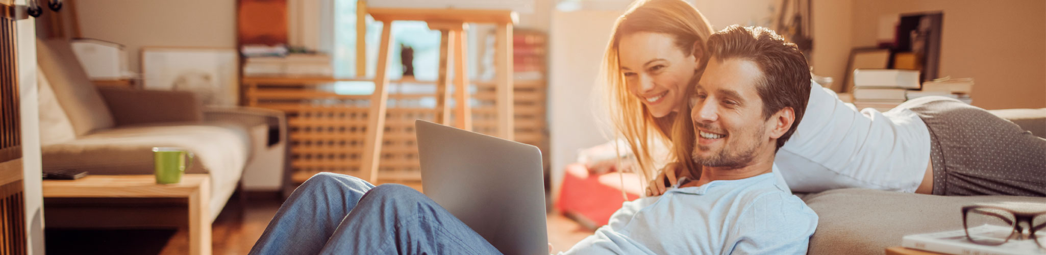 Family in kitchen looking at laptop