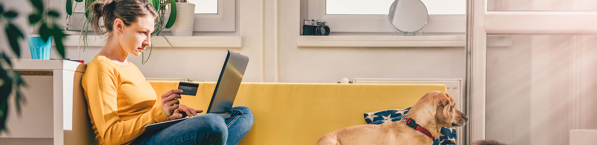 A woman shops online from her couch at home