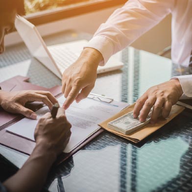 Close up of person's hands signing loan document