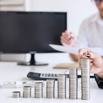 stacks of coins with people in a meeting