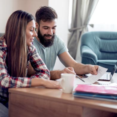 Couple looking through financial paperwork in living room