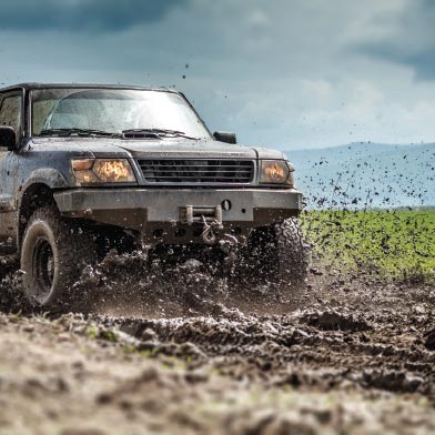 Image of a vehicle driving through the mud on a cloudy day