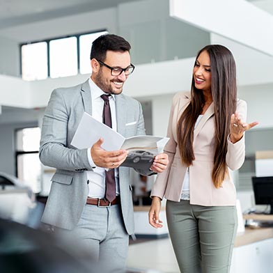 Car salesman and woman negotiating at a car dealership