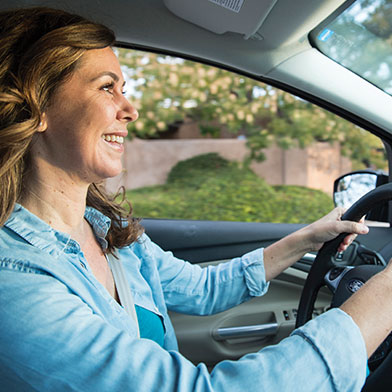 Woman smiling and driving car