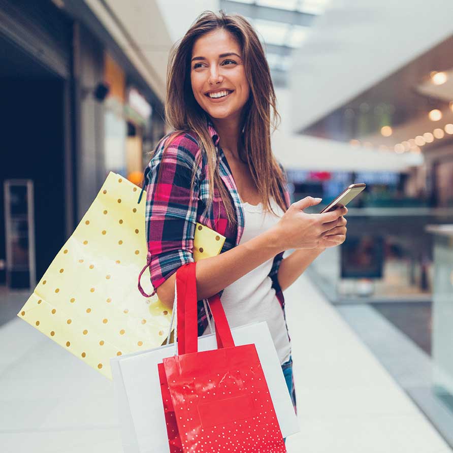 Girl Shopping at the mall with cellphone in hand