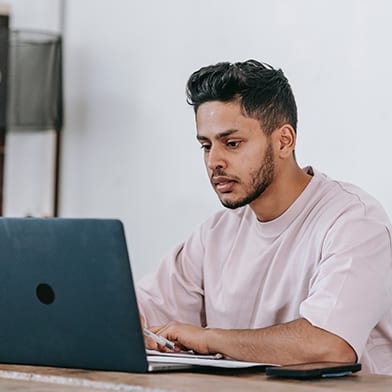 Young man reading on a laptop