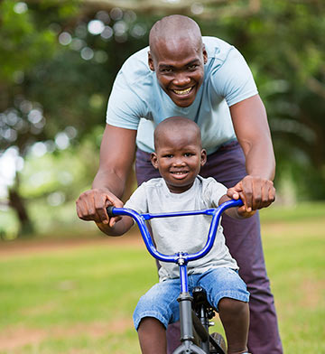 Father teaching son how to ride a bike.