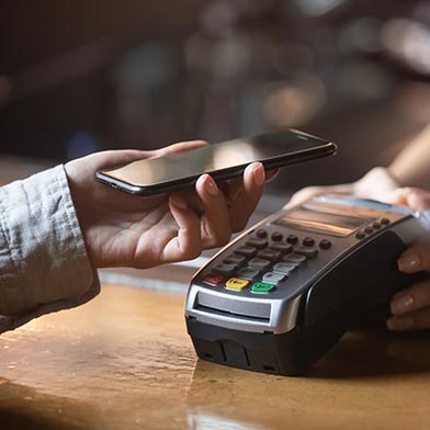 Woman using phone to make contactless payment