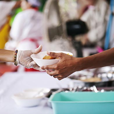 Close up of someone handing a meal to another person