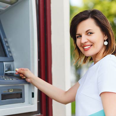 Woman inserting card into ATM.