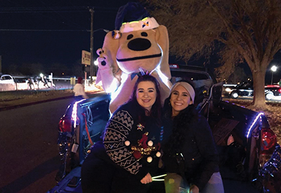 Sunward Employees and Sandy the Lab pose in the back of a decorated truck for the Christmas Electric Light Parade