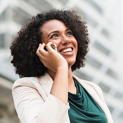 Woman wearing blazer talking on phone.