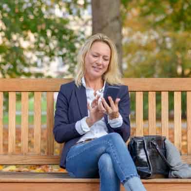 Woman using phone on a park bench