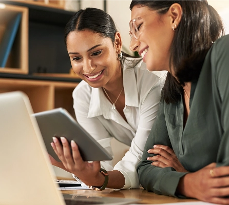 A woman with a laptop smiling at a man who is in the foreground on the left of frame