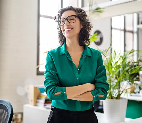 A well-dressed woman in a well-lit office with potted plants