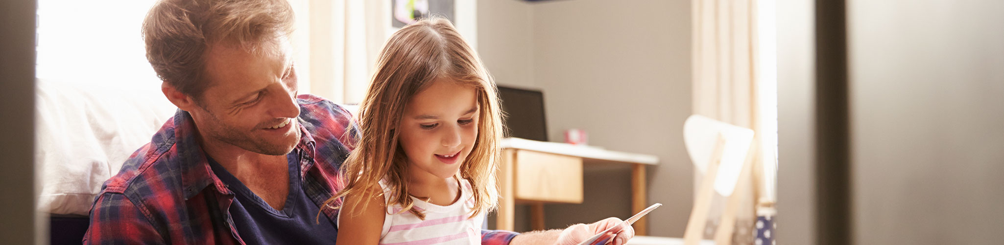 A father and daughter reading together